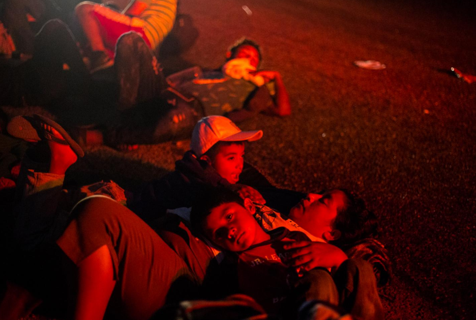 Dos hermanos descansan a la orilla de la carretera México 190, en la madrugada del 27 de octubre. Desde Ciudad Hidalgo, Chiapas, hasta Puebla, han recorrieron 1,114 kilómetros. -Algunos tramos los hicieron en camiones o autos que les dan aventón, y otros caminando.
