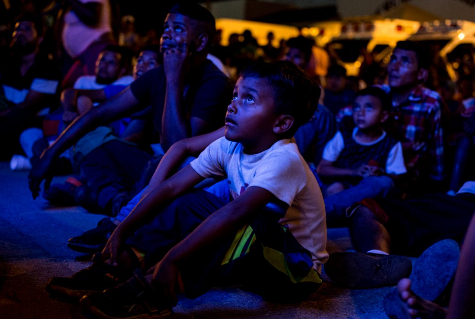 Un niño migrante mira un película en el albergue provisional en Sayula de Alemán, Veracruz.