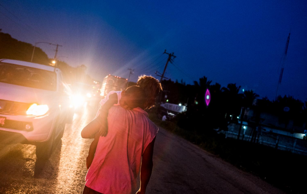 Luis Martínez, de 29 años, carga a su hijo Fernando Martínez, de uno, mientras pide limosna en el municipio de Matías Romero, Oaxaca. Ellos son salvadoreños que decidieron unirse a la caravana migrante debido a que en dos ocasiones los pandilleros le quitaron la mercadería que vendían en el occidente de El Salvador, lo que provocó su huida.  